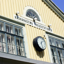 Yksityiskohta Rauhanaseman julkisivusta: Kellotaulu ja kyltti, jossa lukee Rauhanasema Fredsstationen