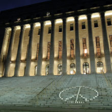 YK-päivän rauhanmerkki eduskuntatalon portailla