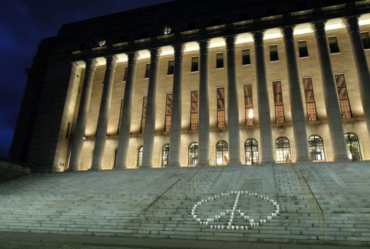 YK-päivän rauhanmerkki eduskuntatalon portailla